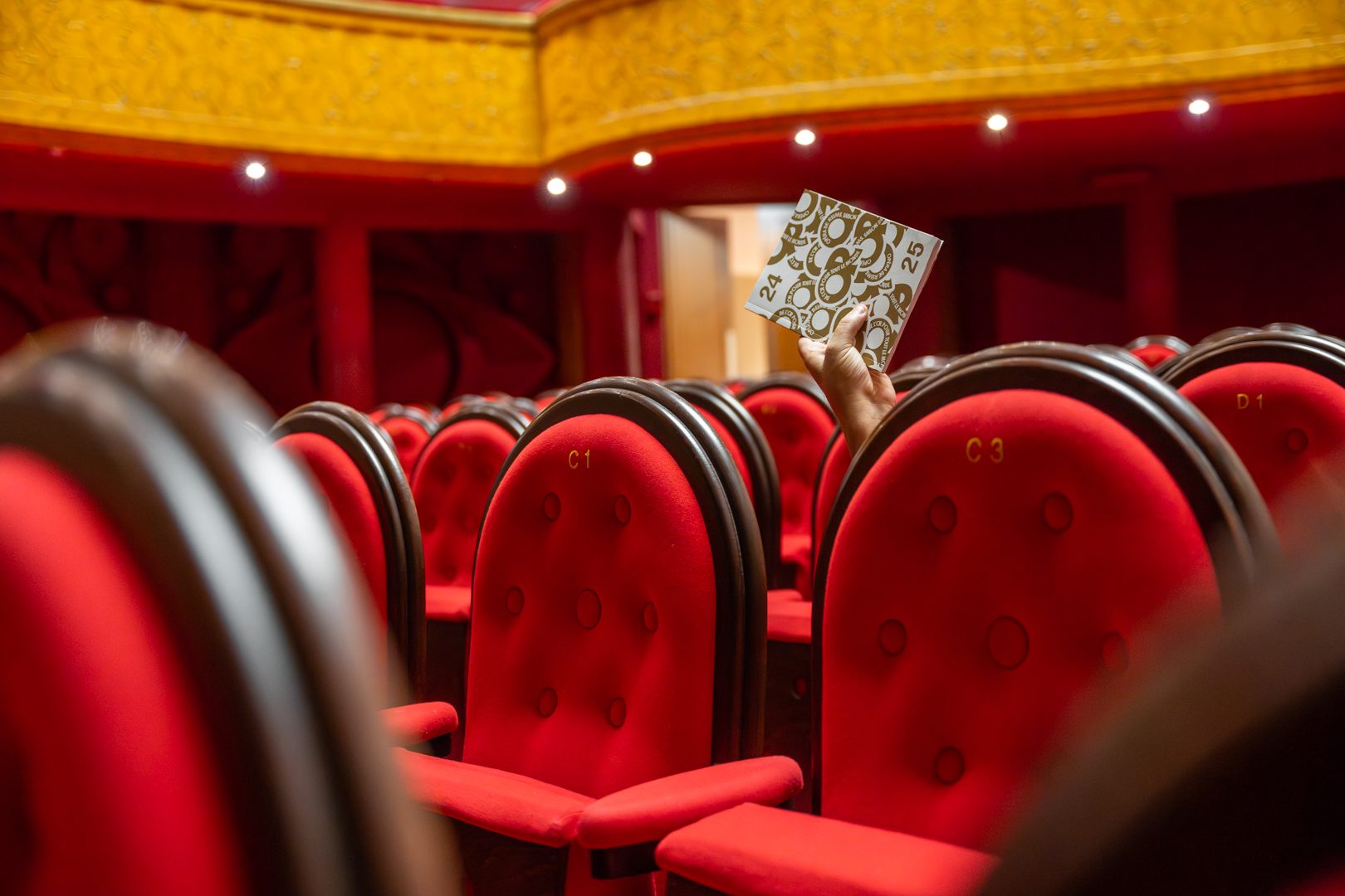 Programme de saison de l’Opéra de Reims posé sur les fauteuils rouges de la salle