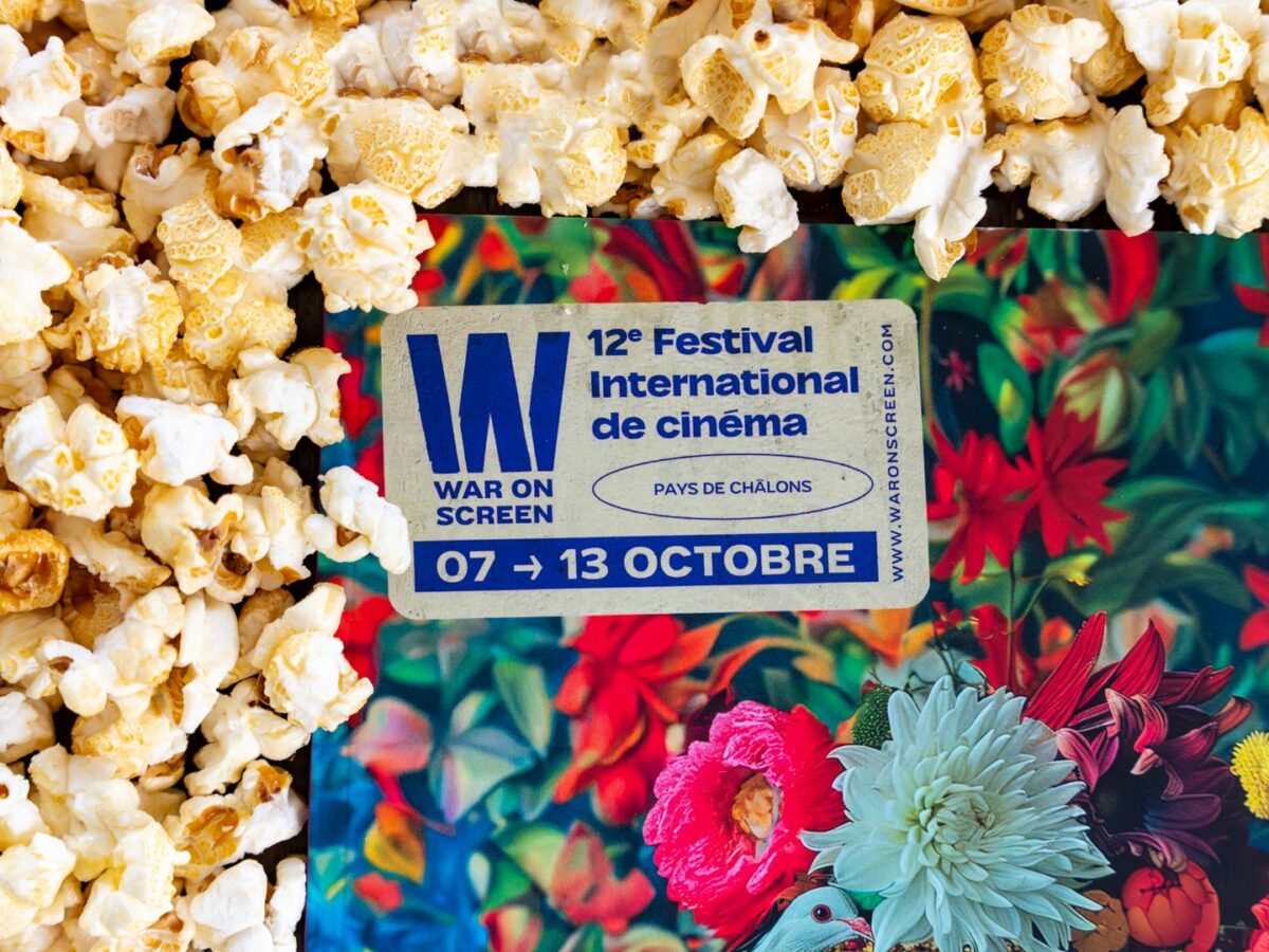 Programme du festival War on Screen posé sur un lit de popcorn