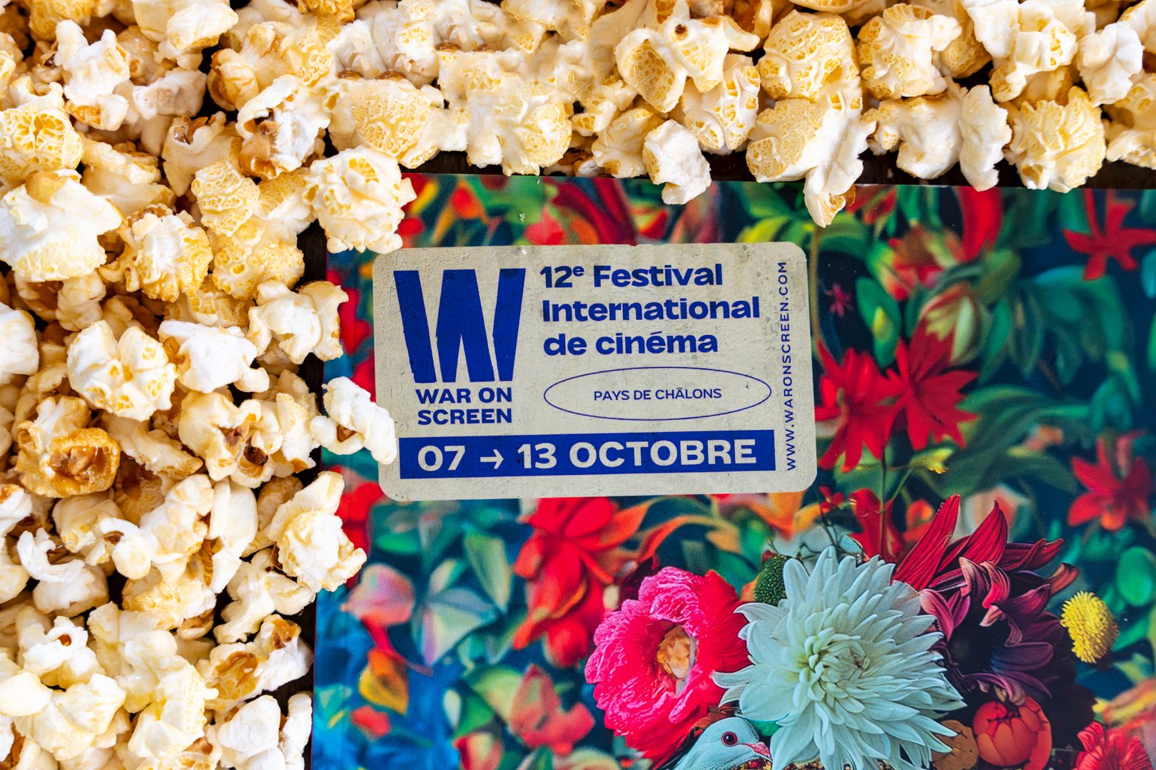 Programme du festival War on Screen posé sur un lit de popcorn
